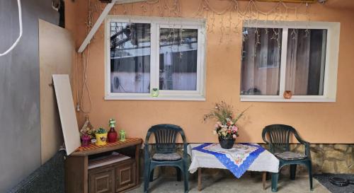 a table with two chairs and a table with flowers on it at Amya - Centrul istoric in Braşov