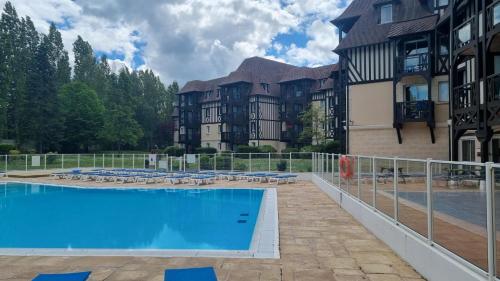 une grande piscine devant un immeuble dans l'établissement 2 pièces avec piscine chauffée, à Deauville