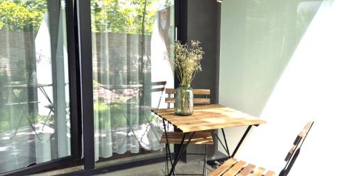 uma mesa com um vaso ao lado de uma janela em Royal Smart Apartments Cracow na Cracóvia