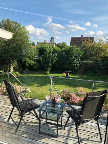two chairs and a glass table on a deck at Beautiful hygge apartment Dk in Søborg