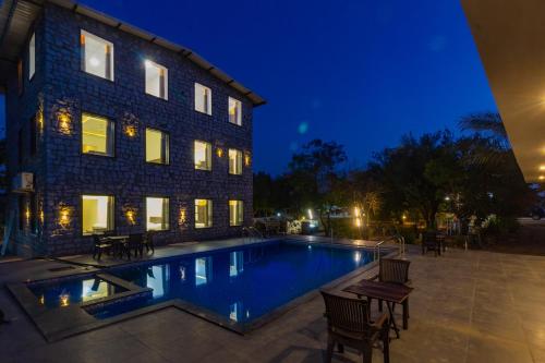 una piscina frente a un edificio por la noche en Jawai Dam Stay, en Bīsalpur