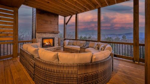 a living room with a couch and a fireplace on a porch at Boundless Views in Mashburn Mill