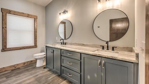 a bathroom with a sink and two mirrors at Boundless Views in Mashburn Mill