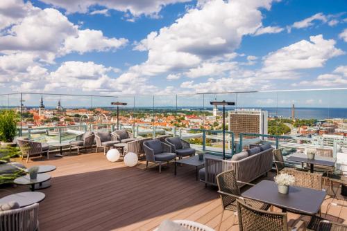 a rooftop deck with chairs and tables and a view of the city at Radisson Collection Hotel, Tallinn in Tallinn