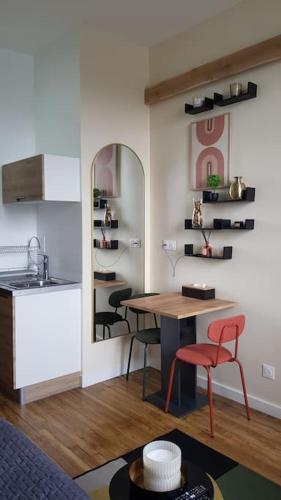 eine Küche mit Tisch und Stühlen in einem Zimmer in der Unterkunft Petit studio Magellan in Nantes