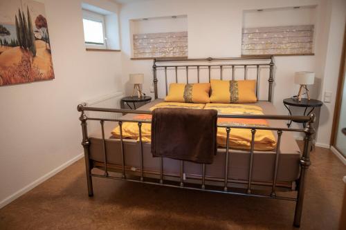 1 dormitorio con 1 cama de metal y 2 lámparas en Gästewohnung am Sonnenstein en Brehme