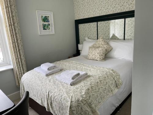 1 dormitorio con 1 cama con toallas en Artists’ Cottages, en Harrogate