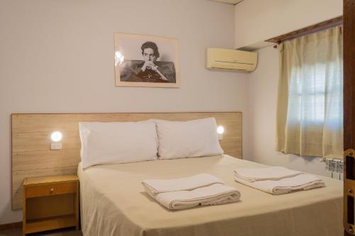 a bedroom with a bed with two towels on it at Hotel de Cine Las Golondrinas in Villa Gesell