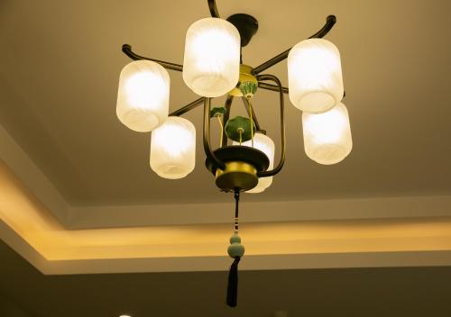 a chandelier with five lights on a ceiling at Rong Hotel - Beijing Nanluoguxiang Branch in Beijing