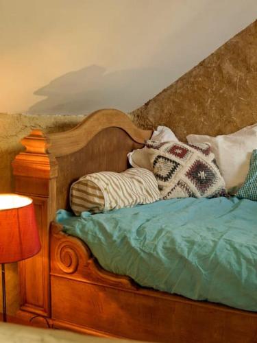 - un lit en bois avec des oreillers au-dessus dans l'établissement La Maison Cabane, à Saint-Martin-le-Hébert