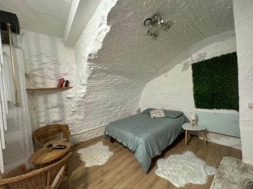 - une chambre avec un lit et un mur en briques blanches dans l'établissement « La Coquille Ancrée », à Dieppe