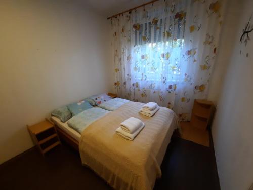 a bedroom with a bed with two towels on it at Arsenal sorházi apartman in Balatonfůzfő