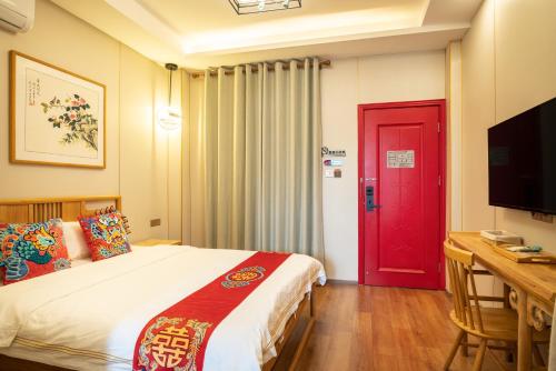 a bedroom with a bed and a red door at Rong Hotel - Beijing Nanluoguxiang Branch in Beijing