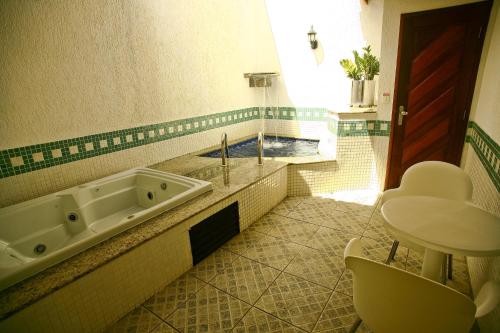 y baño con bañera y lavamanos. en Vert Motel Parnamirim en Parnamirim