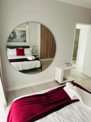 a bedroom with a large mirror and a bed with a bed sqor at Napo Luxury stay in Pretoria