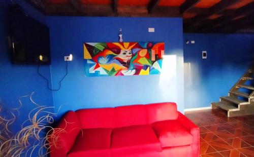 a red couch in a room with a painting on the wall at Cabañas con Tinaja 10 personas in Quillón