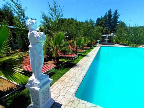 a statue of a woman standing next to a swimming pool at Cabañas con Tinaja 10 personas in Quillón