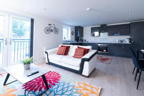 Il comprend un salon avec un canapé blanc et une cuisine. dans l'établissement Brand New Luxury Ground Floor 2 Bedroom Apartment free WiFi & Parking, à Sheffield