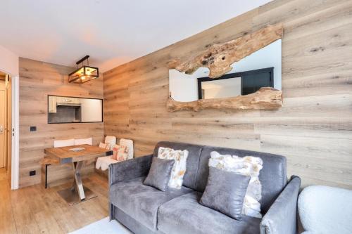 - un salon avec un canapé et un mur en bois dans l'établissement L'Aiguille - maeva Home - Appartement 2 pièces 4 personnes Exclusive MAE-1386, à Chamonix-Mont-Blanc