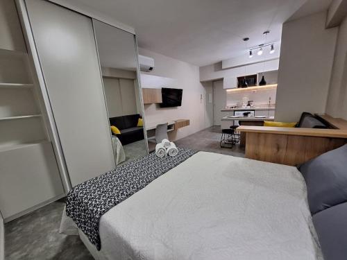 ein Schlafzimmer mit einem großen Bett und einem Spiegel in der Unterkunft Life 914B · LiNDO Estúdio no Lifespace Wifi Ar e TV Smart in Curitiba