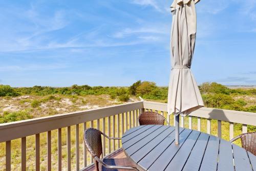 a patio table with an umbrella on a deck at Beach Blessings in Topsail Beach