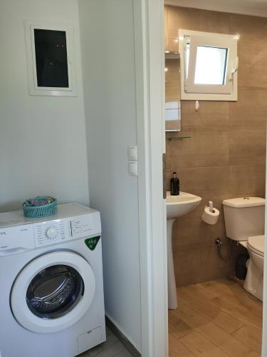 a bathroom with a washing machine and a sink at Tarmaros - Families & Groups in Sissi