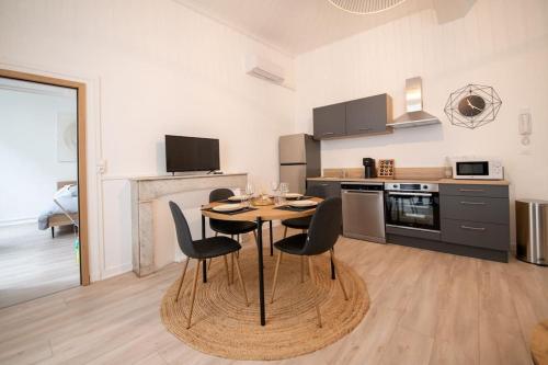 une cuisine avec une table et des chaises dans une pièce dans l'établissement Un Cocon Au Cœur d'Avignon Logement, à Avignon