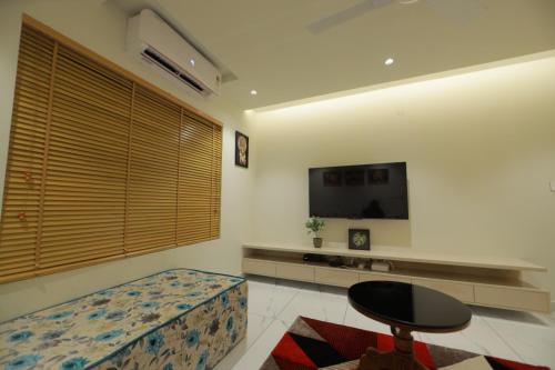a living room with a couch and a tv and a table at 1BHK APPARTMENT @THE CANVAS LOFT in Trivandrum