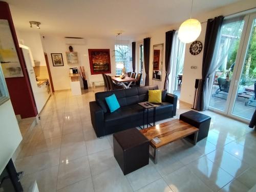 a living room with a black couch and a table at The Forest House Krk 1 in Kras