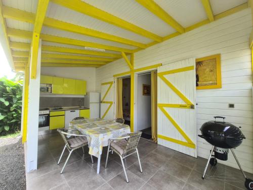 a kitchen with a table and chairs on a patio at Les jardins de Luciole in Saint-François