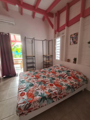 a bedroom with a bed with a floral bedspread at Les jardins de Luciole in Saint-François