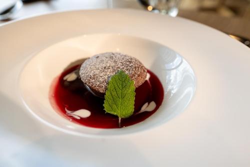 a plate with a chocolate dessert with a leaf on it at Bio Hotel Panorama in Malles Venosta