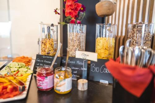 a table topped with vases filled with different types of food at Bio Hotel Panorama in Malles Venosta