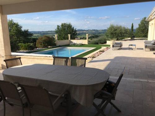 eine Terrasse mit Tisch und Stühlen und ein Swimmingpool in der Unterkunft Maison de vacances avec vue sur la vallée in Fals