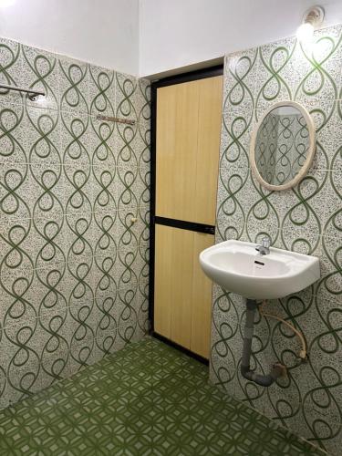 baño con lavabo y espejo en la pared en Sun and Sea, Calangute, en Goa