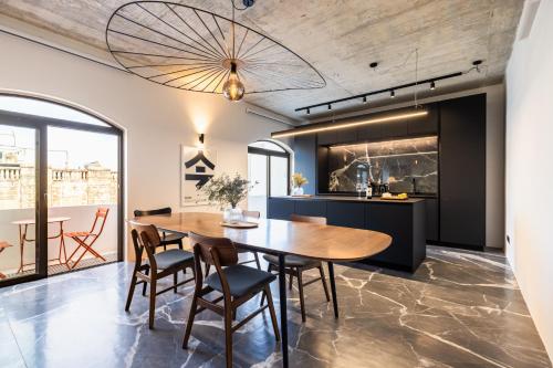 a kitchen and dining room with a wooden table and chairs at Bamboozle Loft in St. Paul's Bay