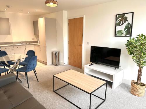 uma sala de estar com uma televisão e uma mesa em Stunning Central Manchester Apartment with Parking em Manchester