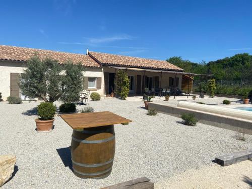a wine barrel with a wooden table in a yard at Villa climatisée avec piscine CHAUFFÉE au cœur du massif d'Uchaux , calme absolu ! in Mondragon
