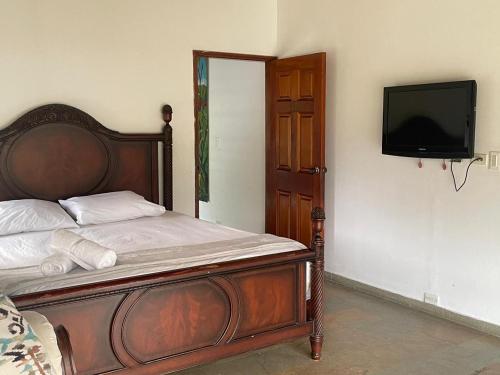 - une chambre avec un lit et une télévision à écran plat dans l'établissement Casa Fuego, à La Pintada