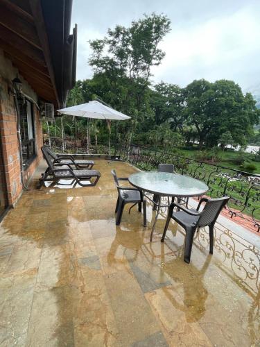 a patio with a table and chairs and an umbrella at Casa Fuego in La Pintada