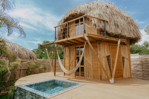 a tree house with a hammock and a pool at JERUSALEMA BEACH GLAMPING in Tolú