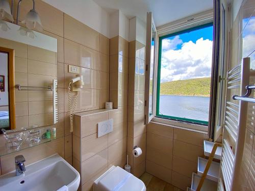 baño con lavabo y ventana en Bed and Breakfast Palac en Valun