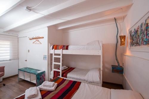 a small room with two bunk beds in it at Hostal Copart in San Pedro de Atacama