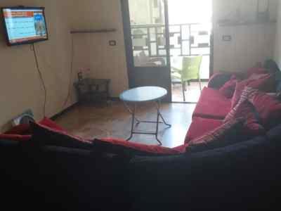 sala de estar con sofá rojo y mesa en La Jerash Inn, en Jerash