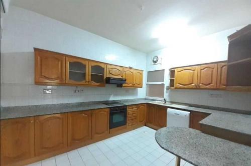 una cocina vacía con armarios y electrodomésticos de madera en La Jerash Inn, en Jerash