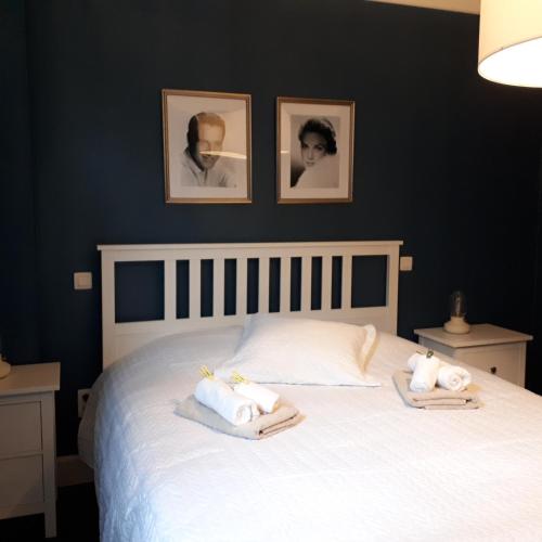 a bedroom with a white bed with towels on it at Het Koetshuis, op 50m van zee, voor 5 personen, centrum Westende BAD, alle comfort in Middelkerke