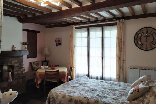 une chambre avec un lit et une horloge au mur dans l'établissement Les Hêtres Inséparables aux portes du DDay, à Bernesq