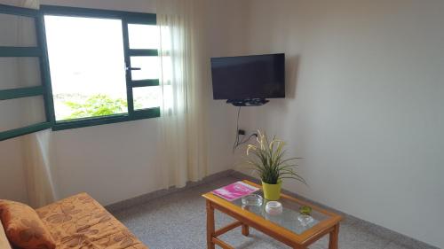 ein Wohnzimmer mit einem TV und einem Couchtisch in der Unterkunft Casitas La Condesa in Valle Gran Rey