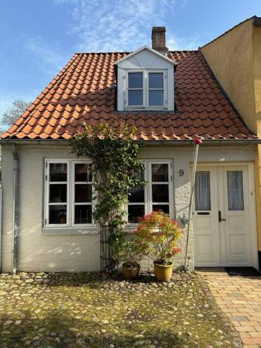 a small white house with a red roof at I hjertet af Tønder by in Tønder