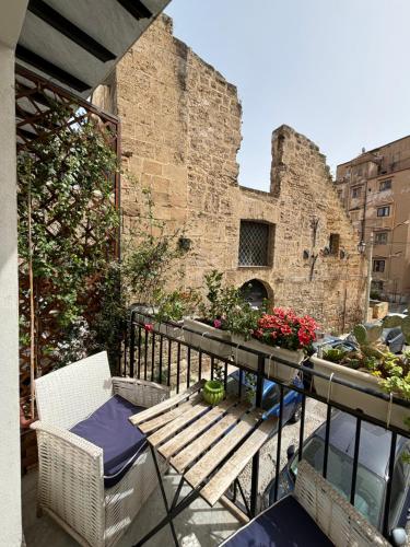 un balcone con tavolo e sedie e un edificio di Real Fonderia b&b a Palermo